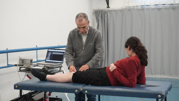 חוקר רפואי בודק את הברך של תלמידת מחול